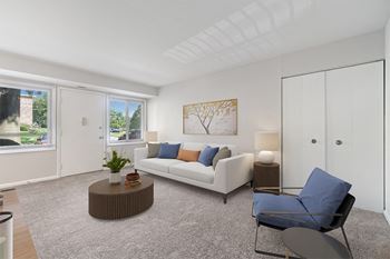 a living room with a white couch and a blue chair at Falls Village Apartments, Baltimore MD